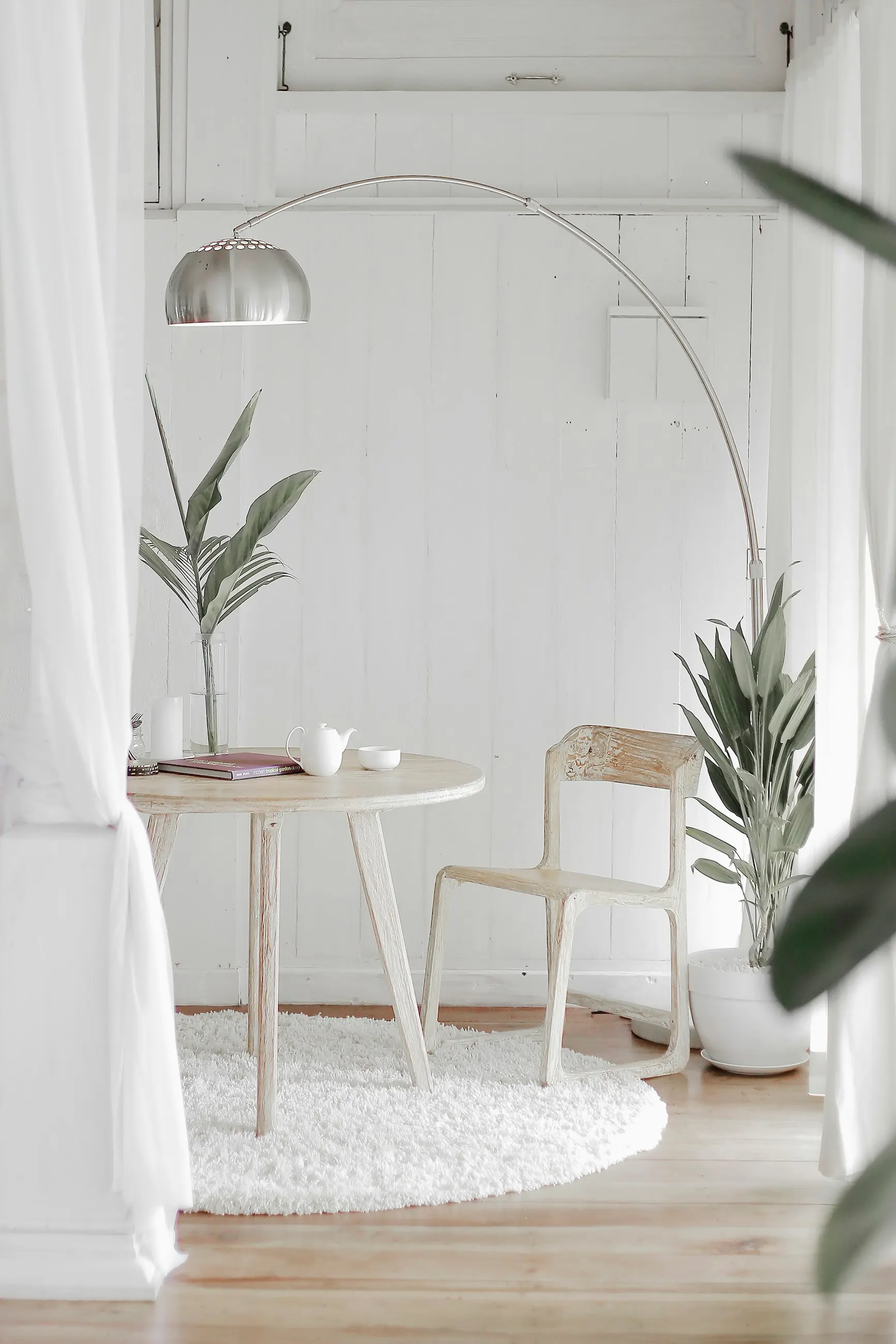 Baño de cal blanca con espejo arqueado y luz natural