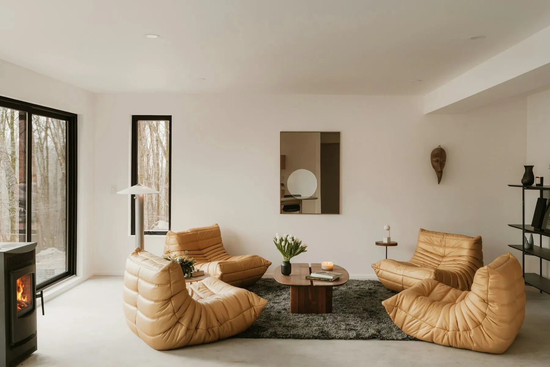 Sala de estar con chimenea encendida y vistas al jardín