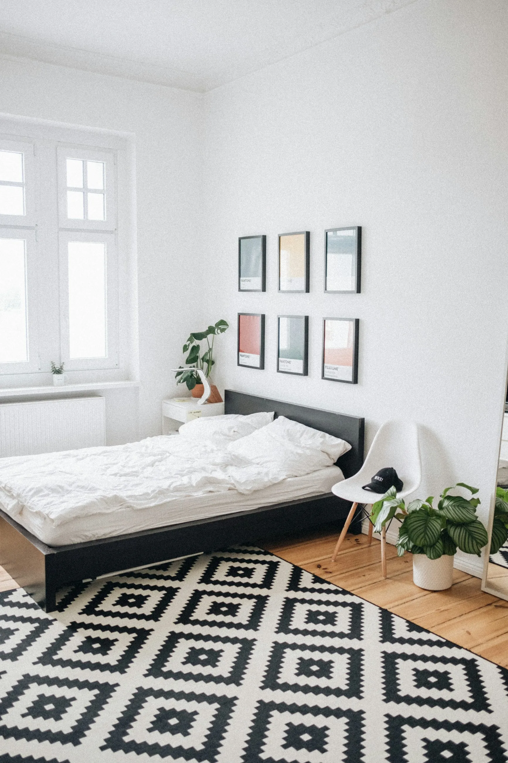 Dormitorio blanco con dosel de madera y luz de mañana